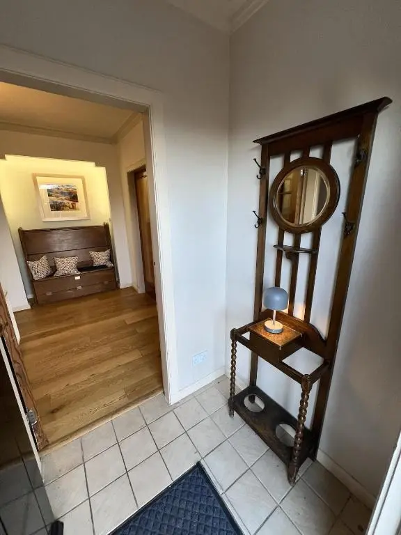 a room with a mirror on a shelf and a hallway at Cluny Corner in Inverness