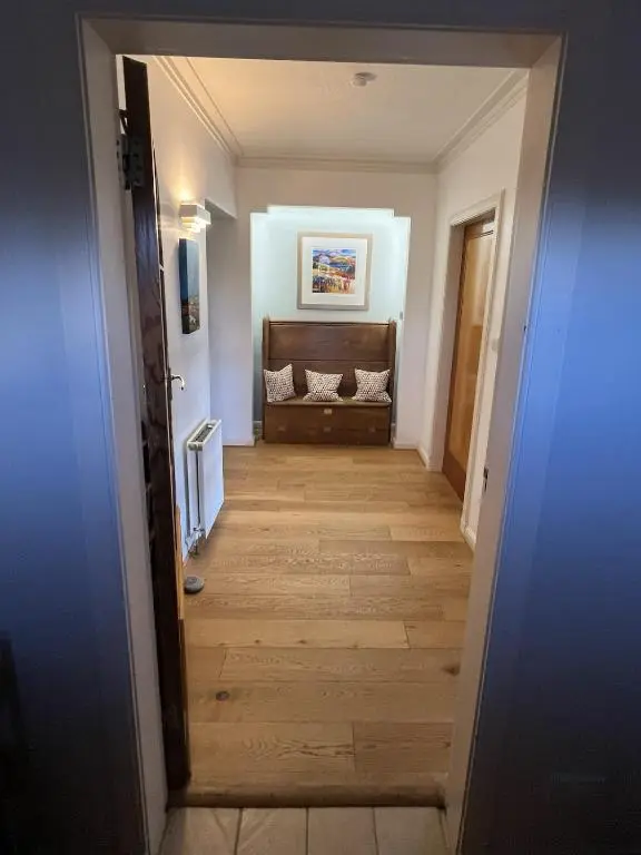 a hallway leading to a living room with a couch at Cluny Corner in Inverness