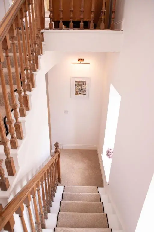 a staircase in a home with white walls and wooden stairs at Calder House, Fochabers in Fochabers