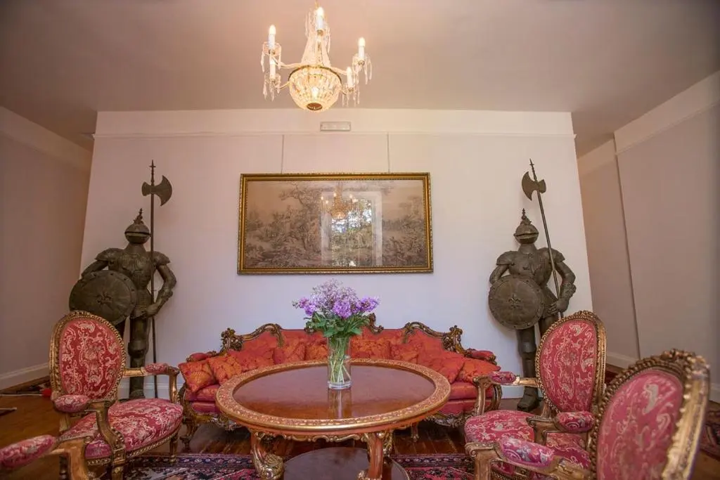 a dining room with a red couch and a table at Averon Castle in Alness