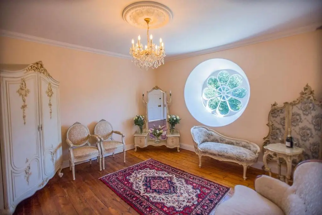 a living room with chairs and a chandelier at Averon Castle in Alness
