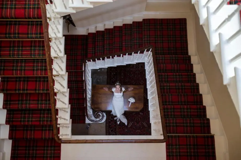 an overhead view of a woman in a white dress on a staircase at Averon Castle in Alness