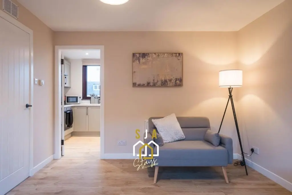 a living room with a chair and a lamp at Fraserburgh Stay - SJA Stays - Modern 2 Bed Apartment in Fraserburgh