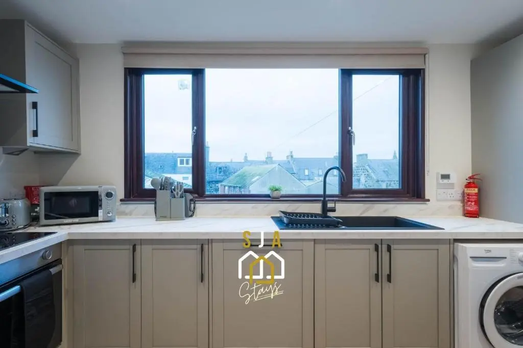 a kitchen with a sink and a window with a view at Fraserburgh Stay - SJA Stays - Modern 2 Bed Apartment in Fraserburgh