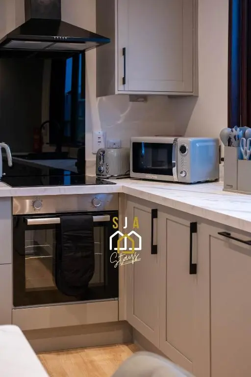 a kitchen with a stove and a microwave at Fraserburgh Stay - SJA Stays - Modern 2 Bed Apartment in Fraserburgh