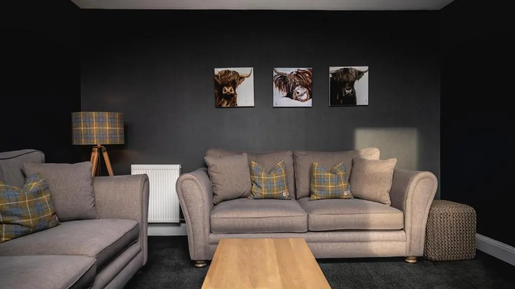 a living room with a couch and pictures on the wall at Burnside, Dornoch in Dornoch