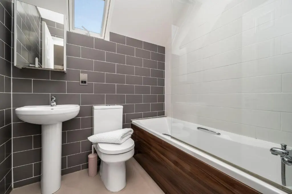 a bathroom with a sink and a toilet and a bath tub at Burnside, Dornoch in Dornoch