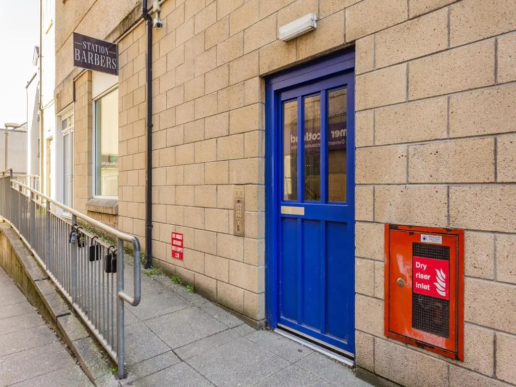 a blue door on the side of a brick building at Inverness Highland Apartment in Inverness