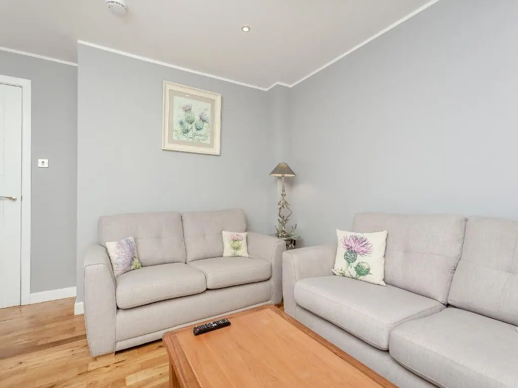 a living room with two couches and a table at Inverness Highland Apartment in Inverness
