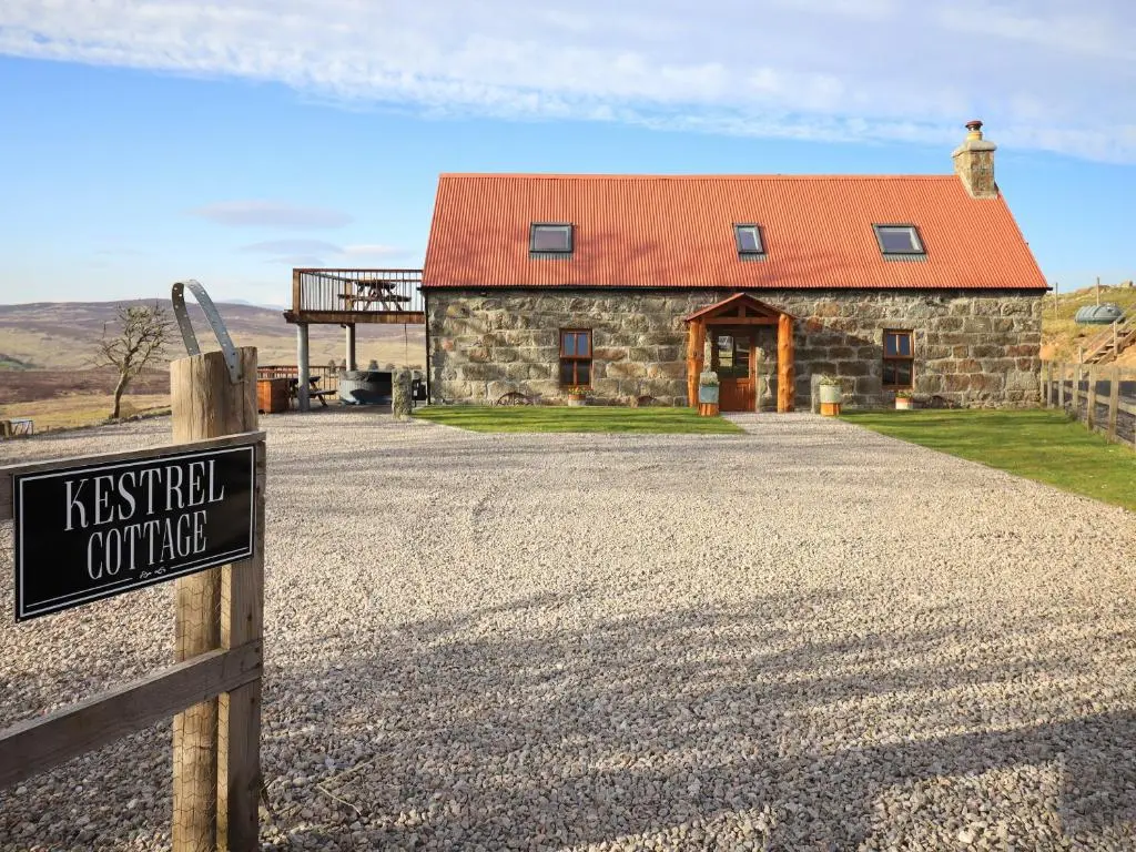 a building with a sign in front of it at Kestrel Cottage in Rogart