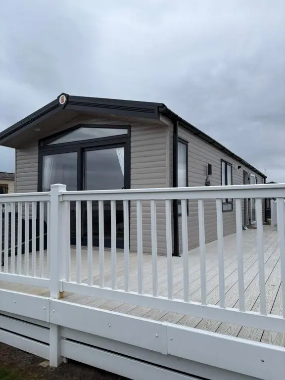 a mobile home with a white fence at Sunset villa in Lossiemouth