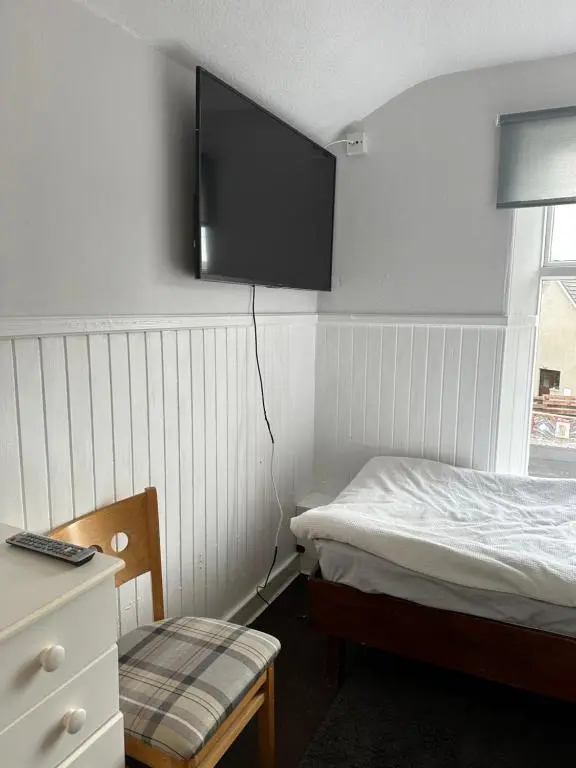 a bedroom with a bed and a tv on the wall at The Staging Post in Aberdeen