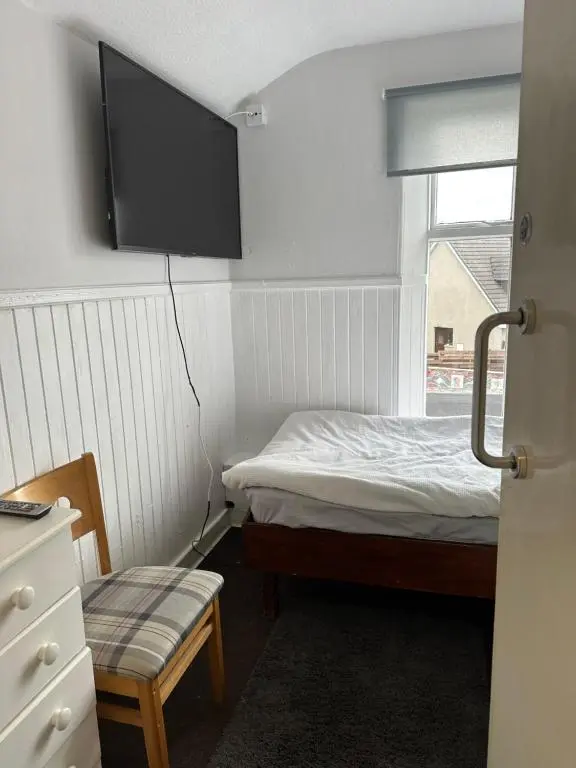 a small bedroom with a bed and a window at The Staging Post in Aberdeen