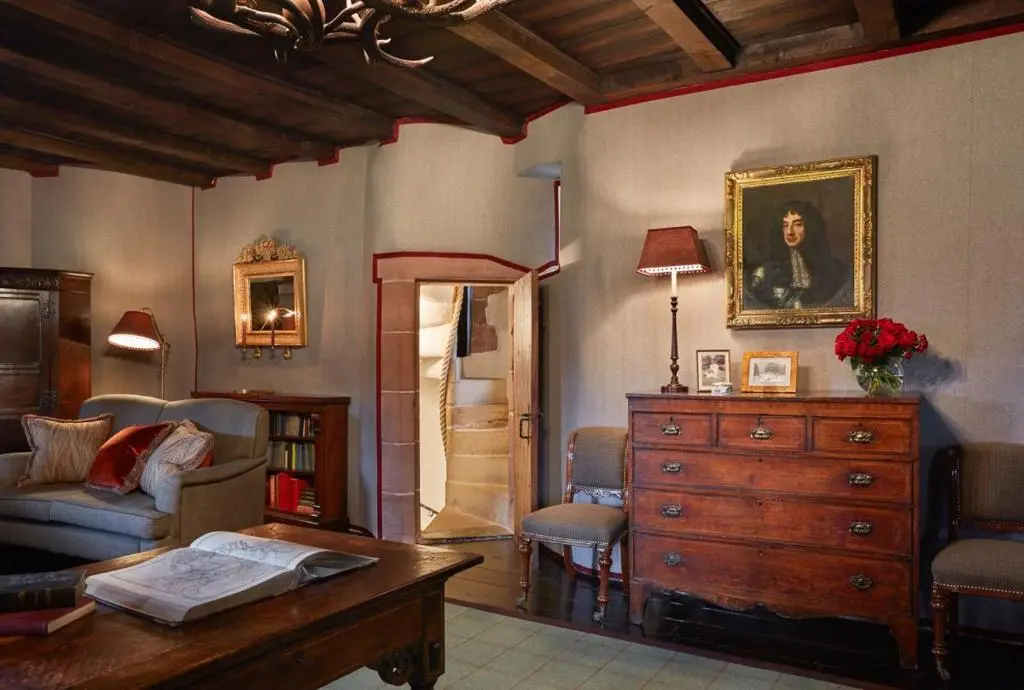 a living room with a couch and a dresser and a table at The Fortalice in Tulchan