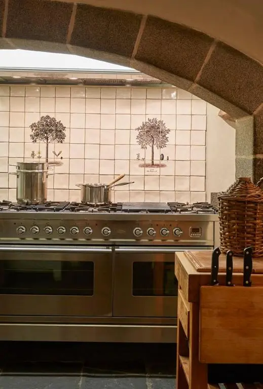 a kitchen with a stove with two pots on the wall at The Fortalice in Tulchan