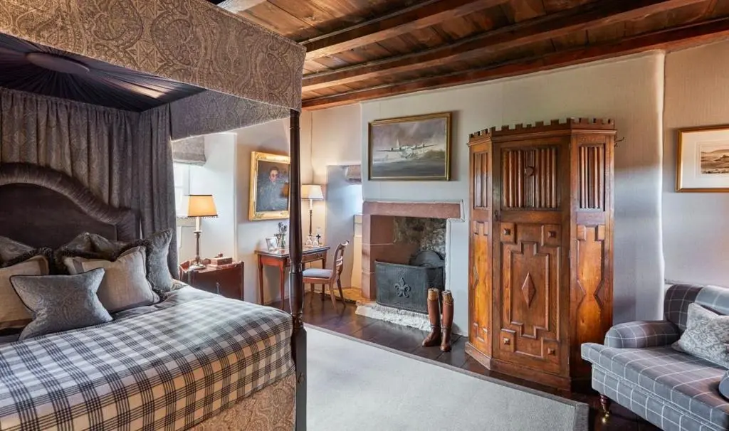 a bedroom with a bed and a fireplace at The Fortalice in Tulchan