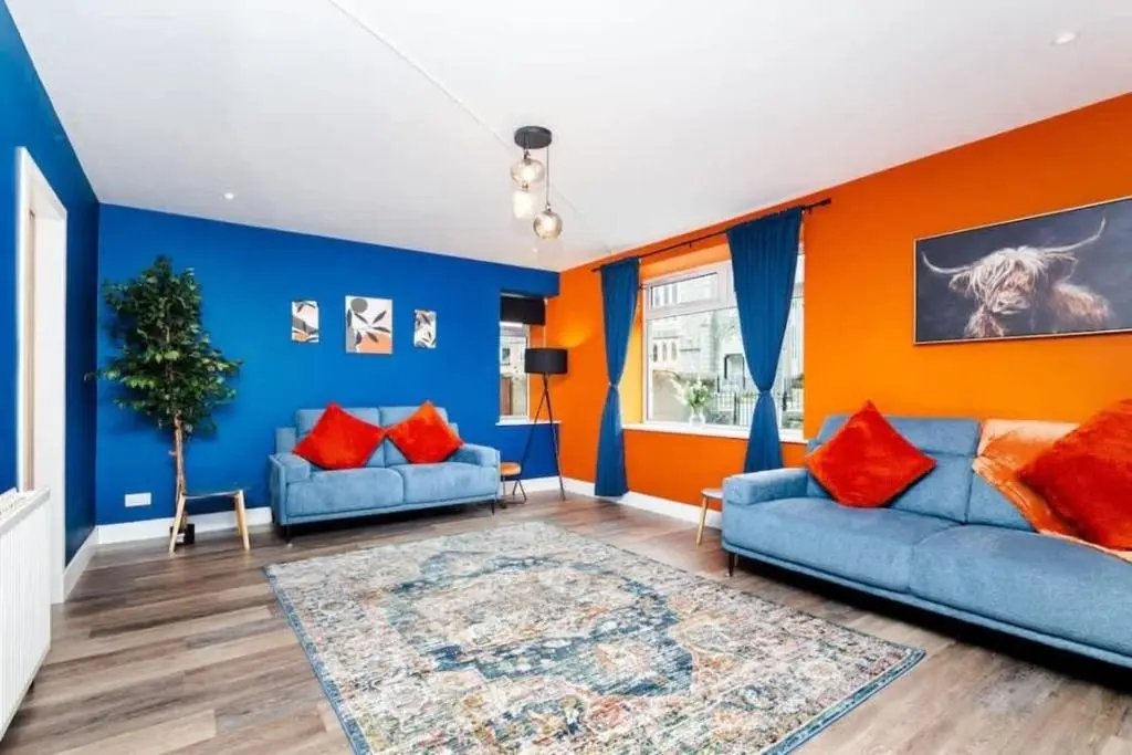 a living room with blue and orange walls at Aberdeen Airport Cozy Apartment - 3 Beds - Sleeps 5 with Free Parking and Fast Wi-Fi in Aberdeen