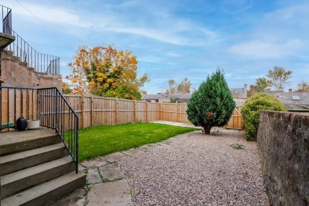 a backyard with a wooden fence and a christmas tree at Aberdeen Airport Cozy Apartment - 3 Beds - Sleeps 5 with Free Parking and Fast Wi-Fi in Aberdeen