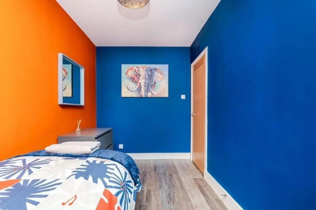 a bedroom with blue and orange walls and a bed at Aberdeen Airport Cozy Apartment - 3 Beds - Sleeps 5 with Free Parking and Fast Wi-Fi in Aberdeen