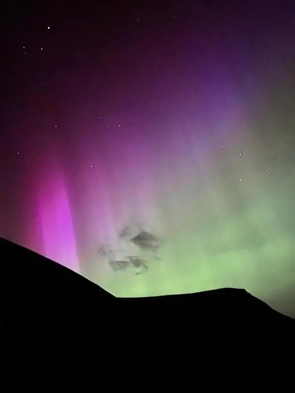 a green and purple sky with the auragogues at Lothmore Lookout - Sunset in Kilmote