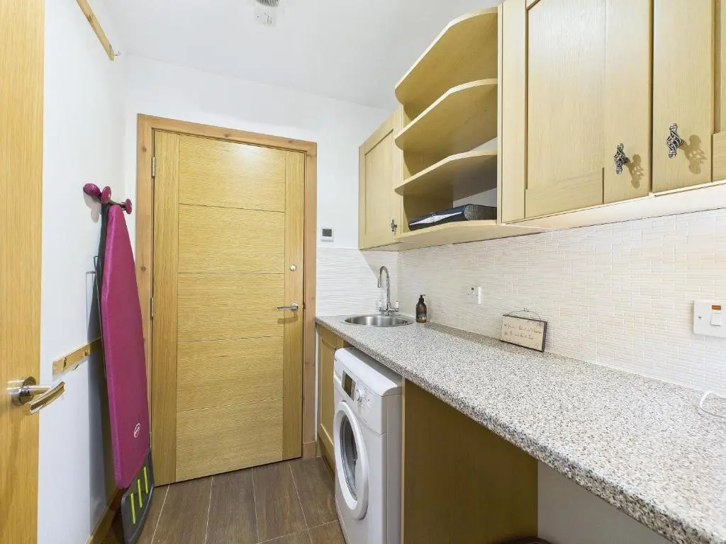 a kitchen with a washer and dryer at The Steadings Aviemore Premium Highland Apartment Near Cairngorms & Town Centre in Aviemore