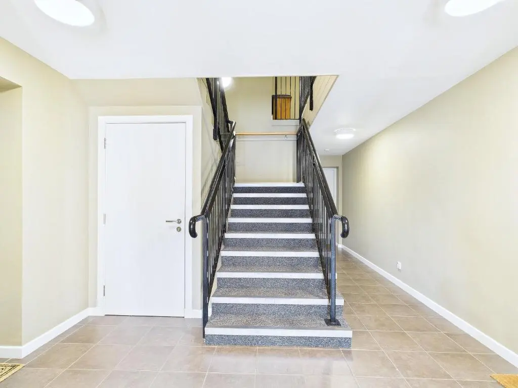 a staircase in a home with a white door at The Steadings Aviemore Premium Highland Apartment Near Cairngorms & Town Centre in Aviemore