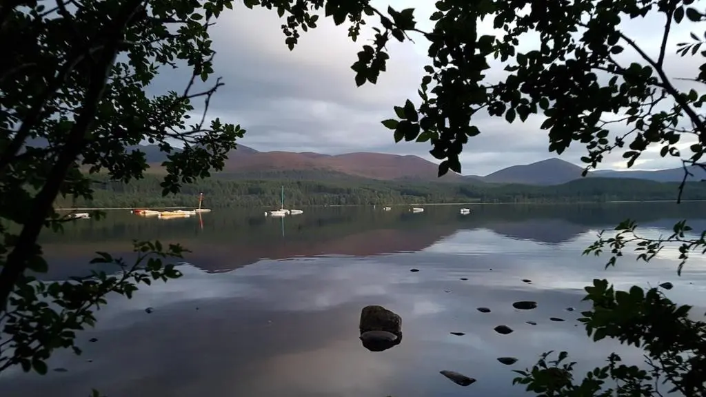 a view of a lake with boats in the water at The Steadings Aviemore Premium Highland Apartment Near Cairngorms & Town Centre in Aviemore