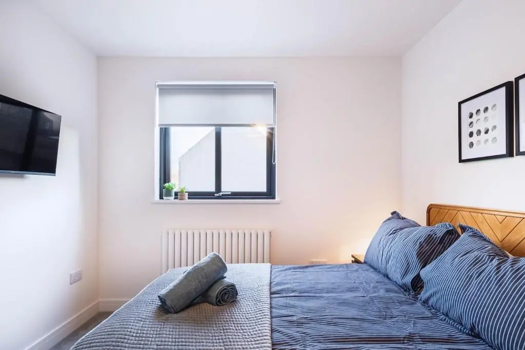 a bedroom with a bed and a window at Modern Central Apartment Huntly in Huntly