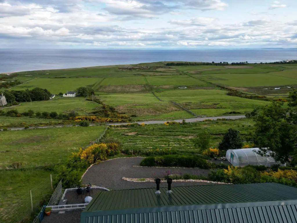 two people standing on top of a building in a field at Lothmore Lookout - Sunrise in Kilmote