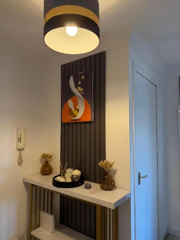 a room with a table with a clock on the wall at Nessy5 Apartment in Inverness