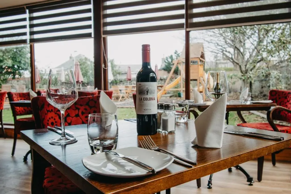 a table with a bottle of wine and glasses at Seafield Arms Hotel in Whitehills