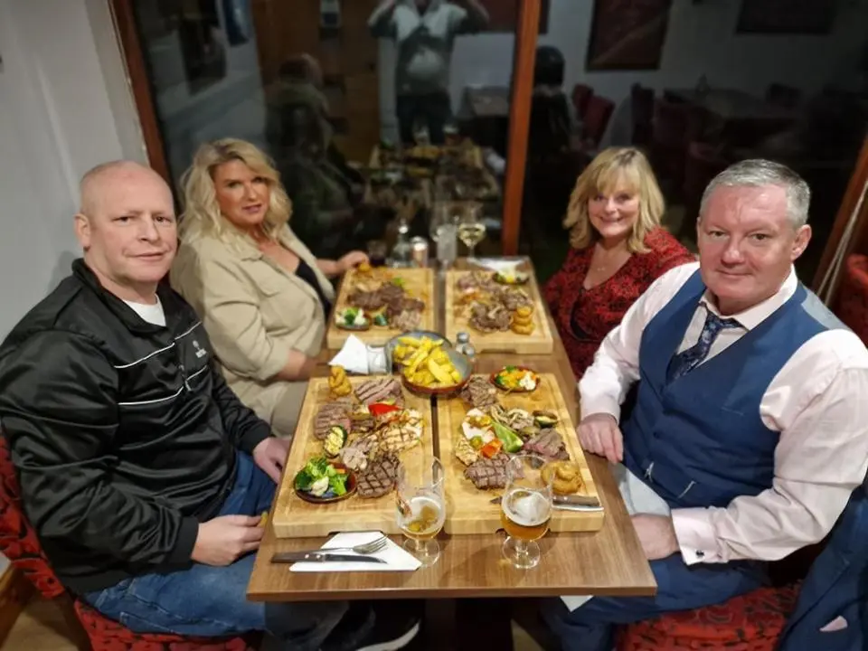 a group of people sitting around a table with food at Seafield Arms Hotel in Whitehills