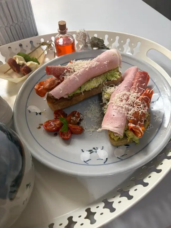 a plate with a sandwich and strawberries on a table at Waterside House B&B in Ullapool