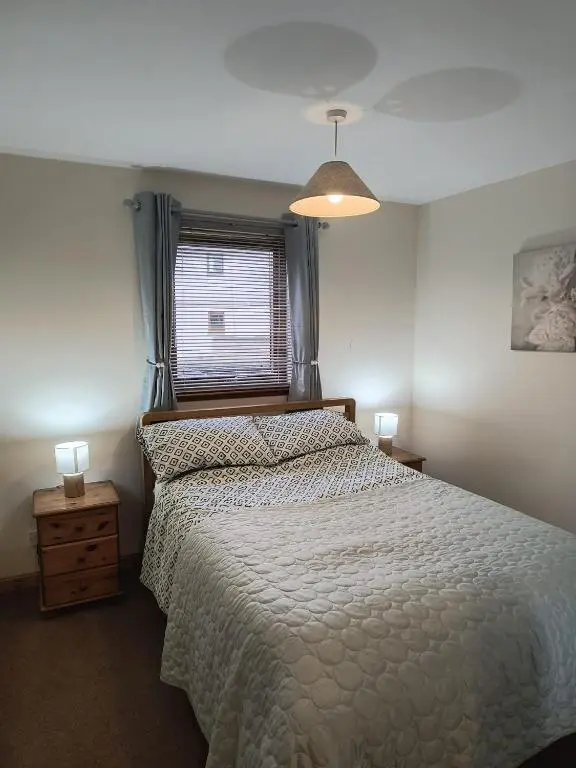 a bedroom with a large bed and a window at Highland Getaway in Inshes