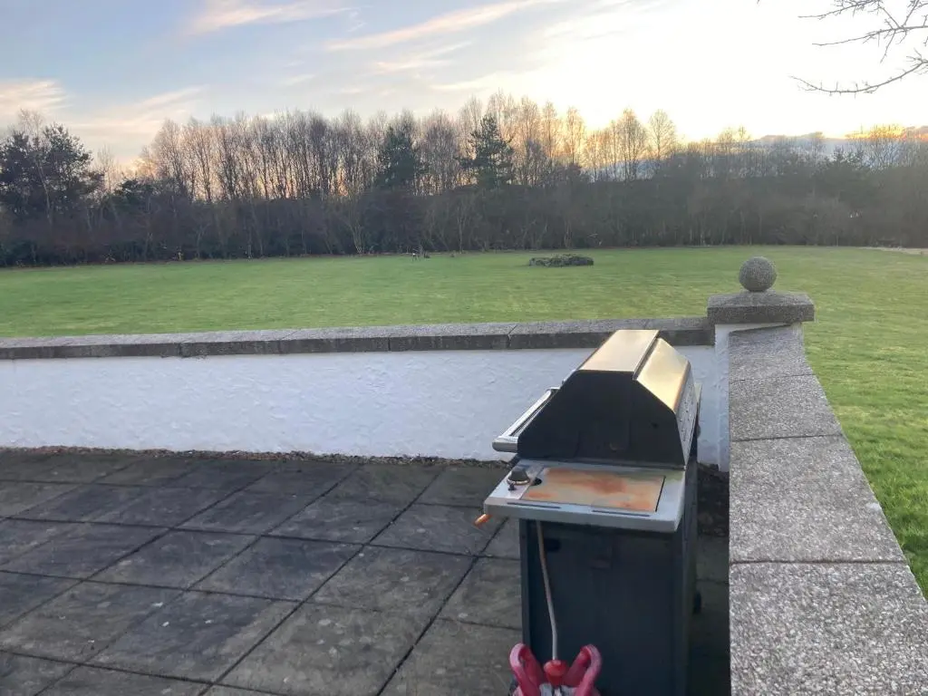 a outdoor grill on a wall next to a body of water at Recently refurbished former art studio in Rothiemay Station