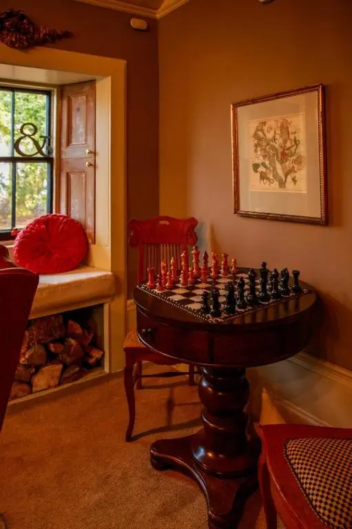a chess board in a room with a chair and a window at Bliss Cottage in Nairn