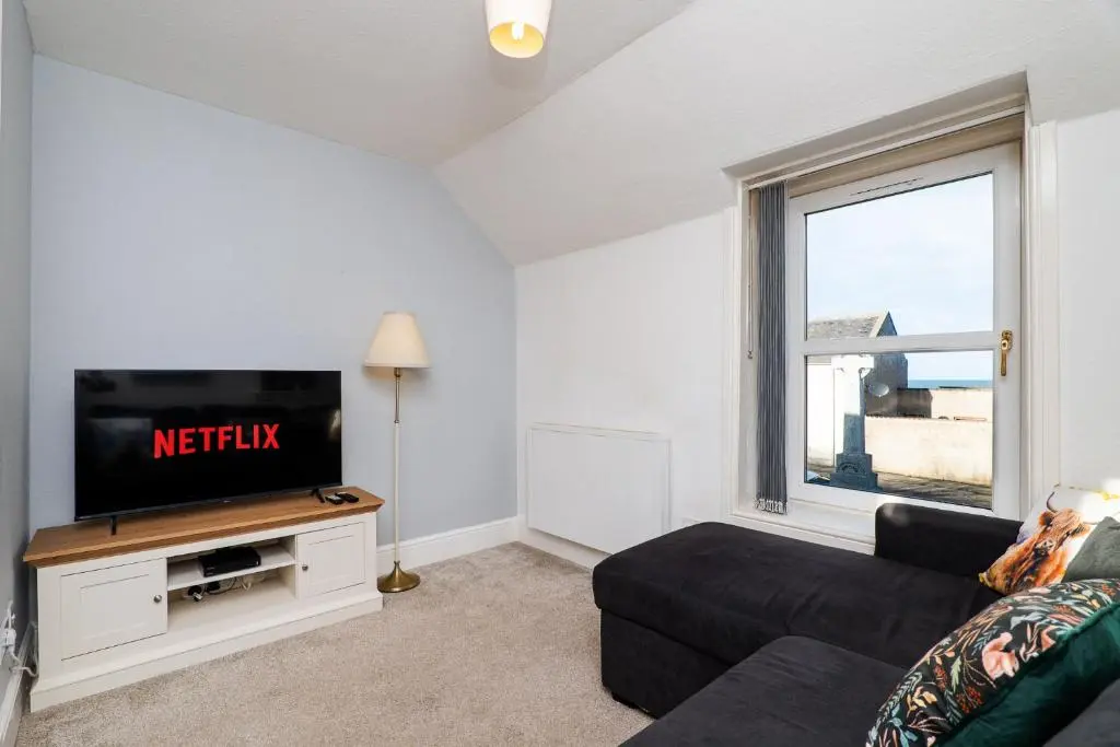 a living room with a tv and a couch at Charming 1-Bed Coastal Cottage by Holiday Homes in Portgordon