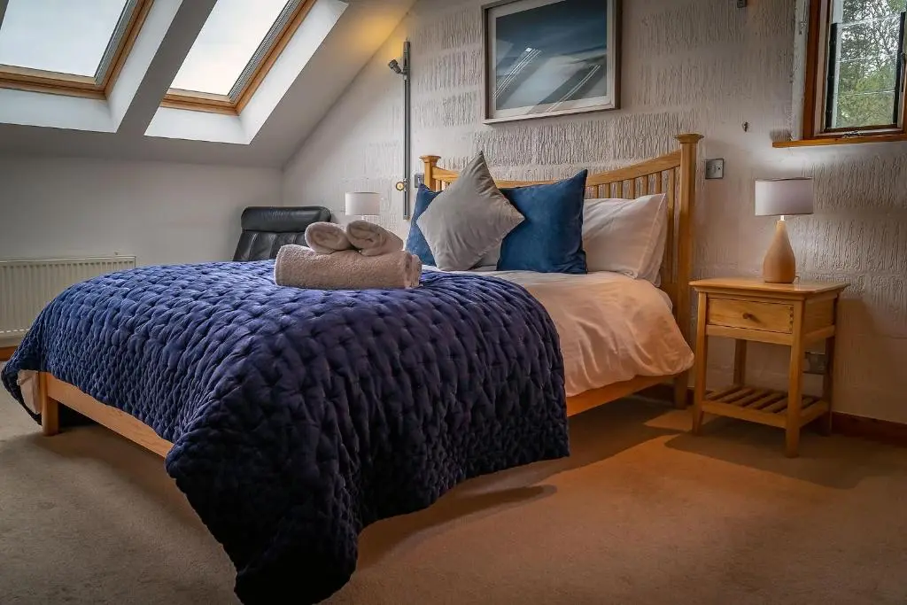 a bedroom with a bed with two teddy bears on it at Kirkstone Lodge in Insh