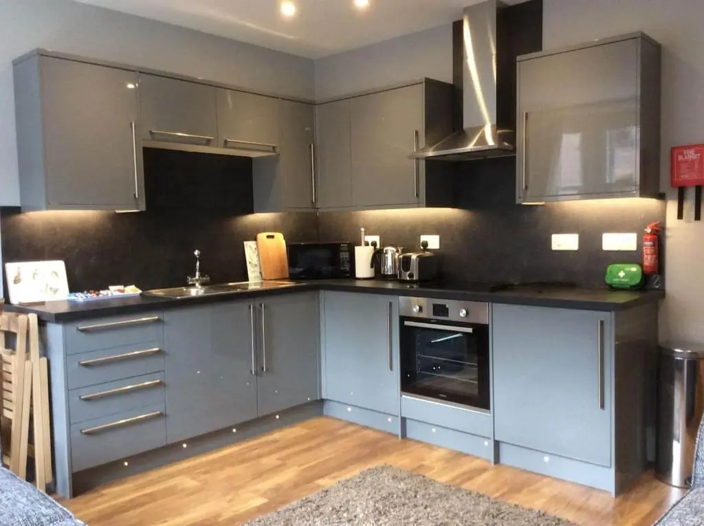a kitchen with stainless steel appliances and gray cabinets at Macdonald Apartment 11C Greig St Inverness IV3 5PT in Inverness