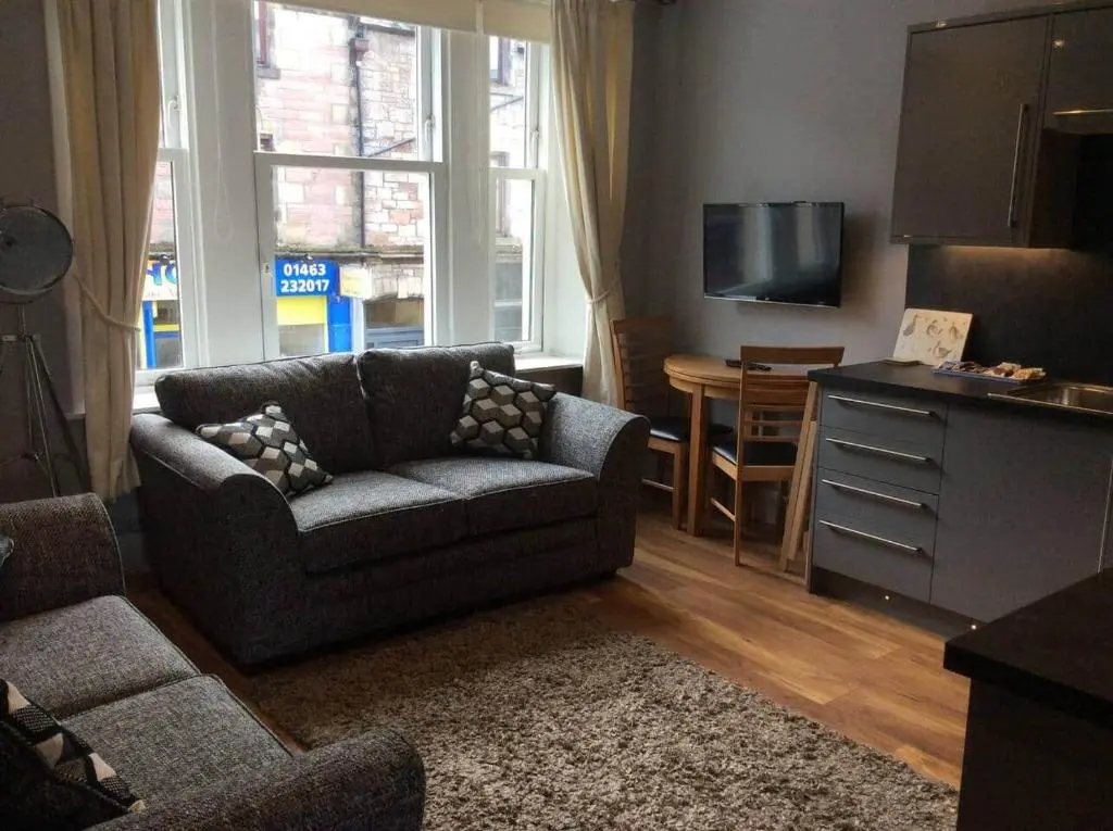 a living room with a couch and a table at Macdonald Apartment 11C Greig St Inverness IV3 5PT in Inverness