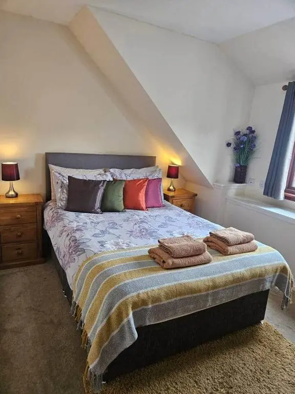 a bedroom with a bed with pillows on it at Flat 3/2 Murray Place Haugh Rd Inverness IV2 4SH in Inverness