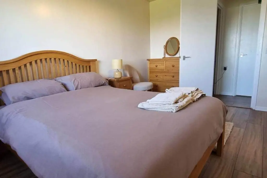 a bedroom with a bed and a dresser and a mirror at Harbour View 45 Anderson Street Inverness IV3 8BU in Inverness