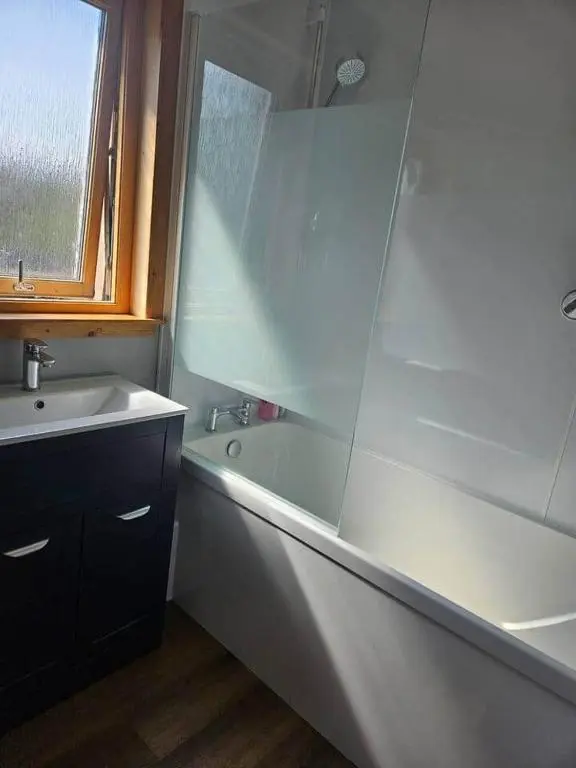 a bathroom with a sink and a bath tub and a sink at Harbour View 45 Anderson Street Inverness IV3 8BU in Inverness