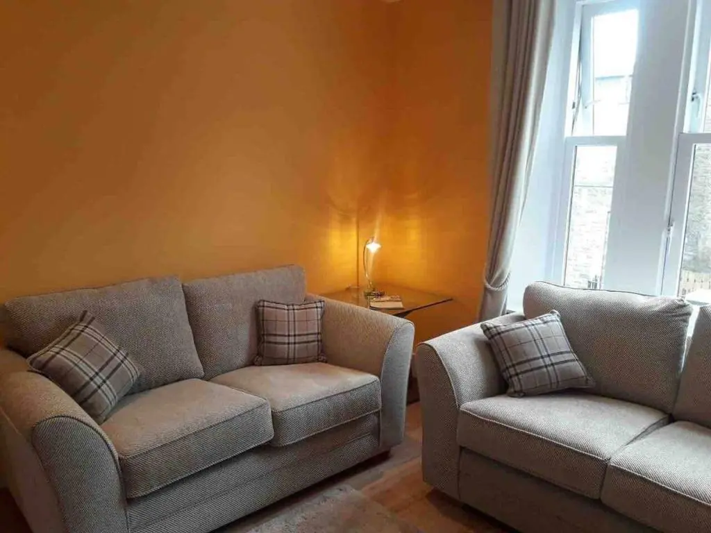 a living room with a couch and a chair at Macdonald Apartments 9C Greig St Inverness IV3 5PT in Inverness