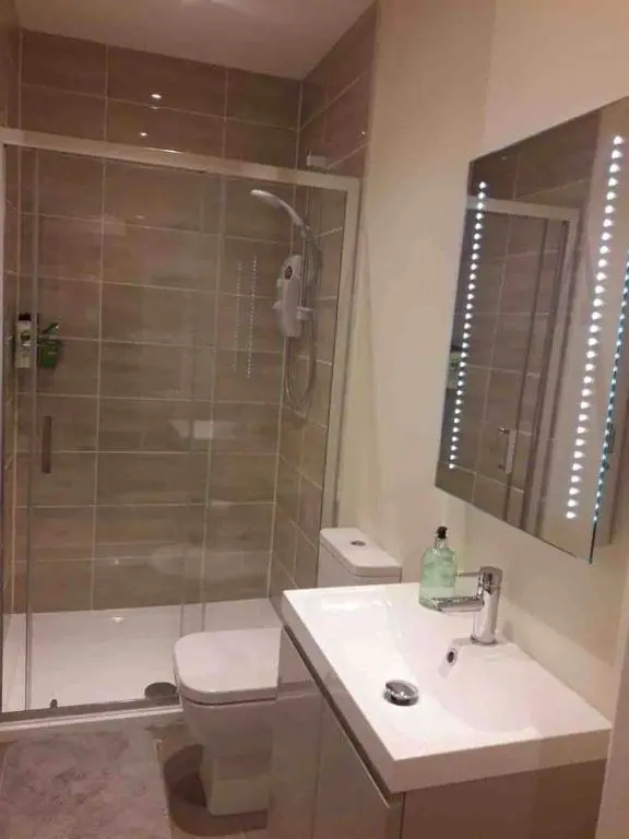 a bathroom with a toilet and a sink and a shower at Macdonald Apartments 9C Greig St Inverness IV3 5PT in Inverness