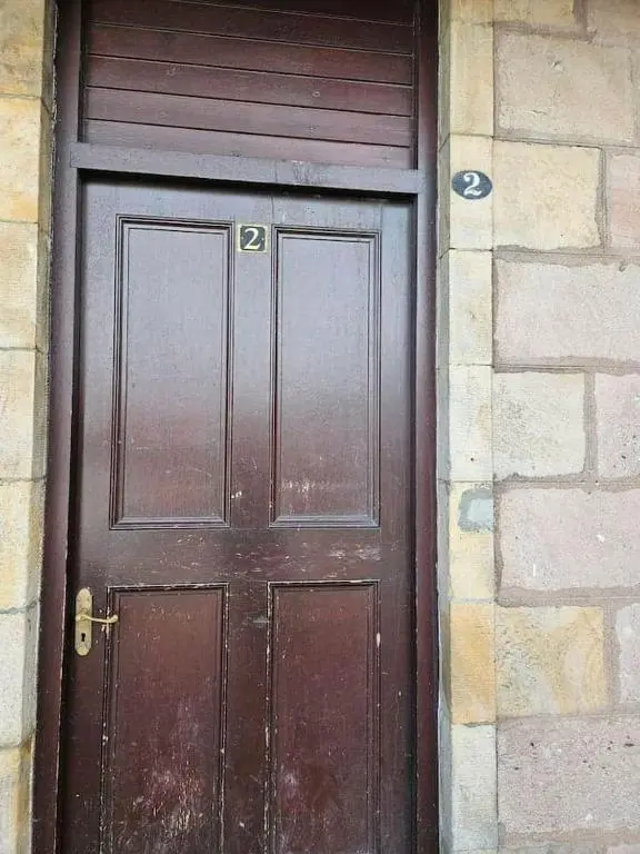 a wooden door in a brick wall with the number at Flat 4 /2 Murray Place Haugh Rd Inverness IV2 4SH in Inverness