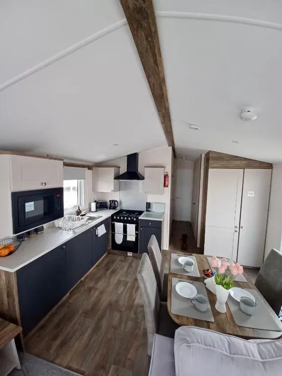 a kitchen and living room with a table and chairs at B17 SilverSands Escape in Lossiemouth