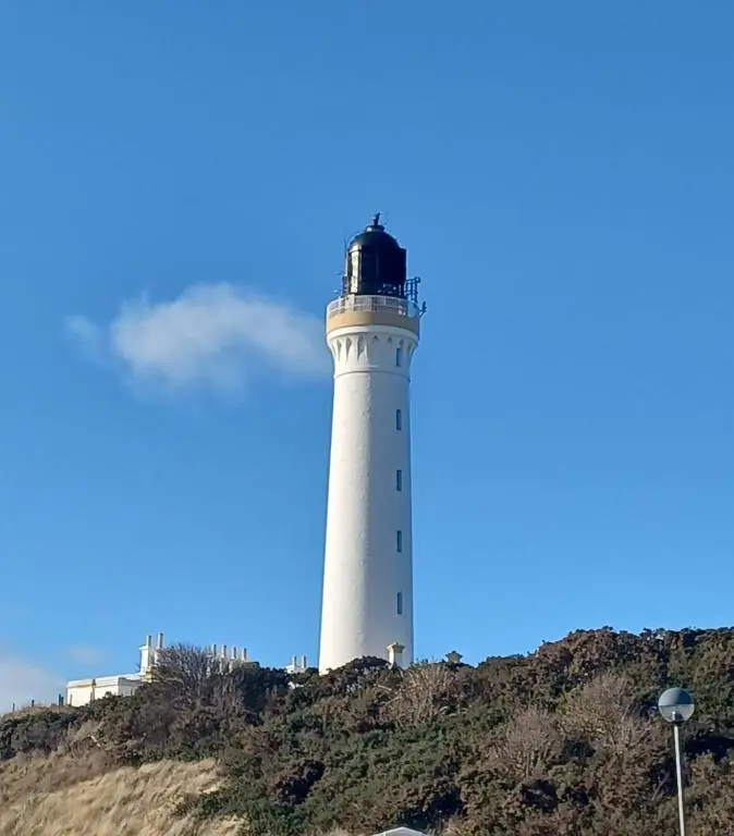 a lighthouse sitting on top of a hill at B17 SilverSands Escape in Lossiemouth
