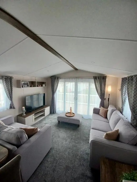 a living room with two couches and a tv at B17 SilverSands Escape in Lossiemouth