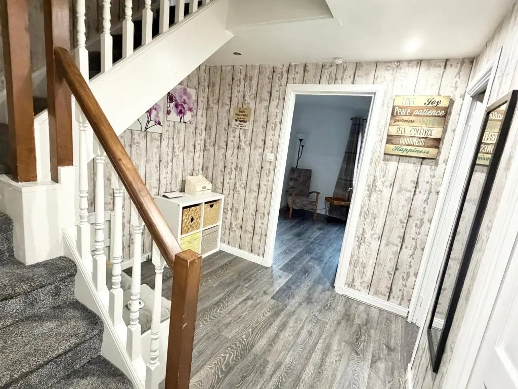 a staircase in a home with wooden floors at Mamore House Inverness in Dalneigh